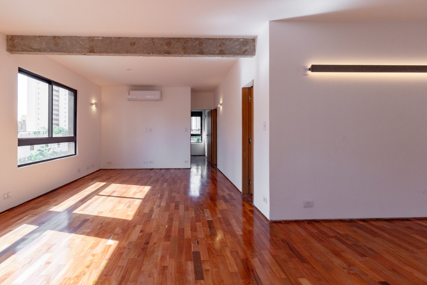 Living do apartamento modelo, com janelas amplas e vista para a cidade